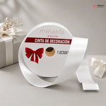 Roll of white decorative ribbon with a red bow design on a gray background