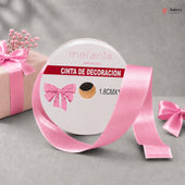 Roll of pink decorative ribbon with a bow on a gray background