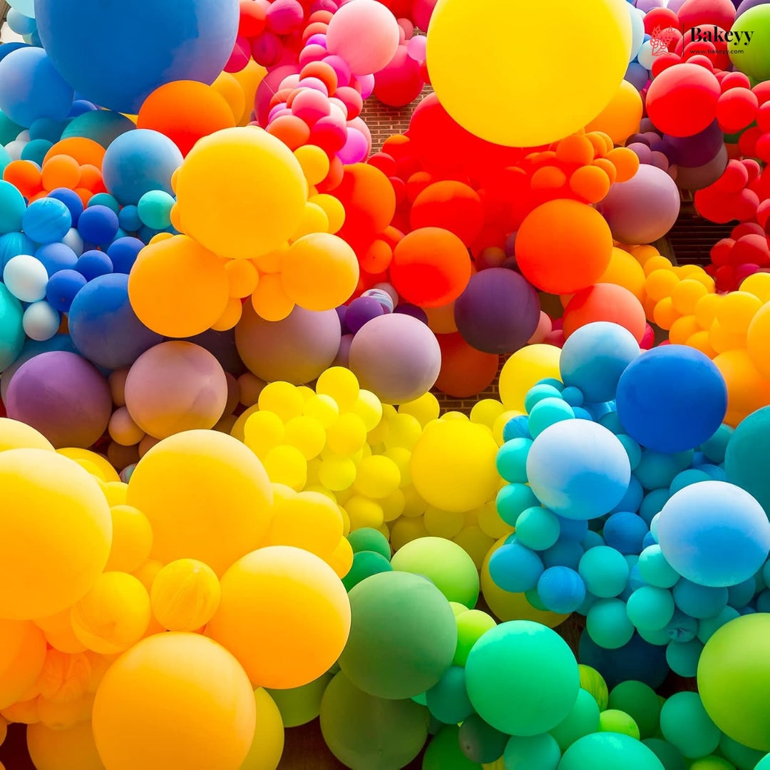 A dense cluster of colorful balloons in bright rainbow shades including yellow, orange, red, blue, green, purple, and pink, filling the entire frame.
