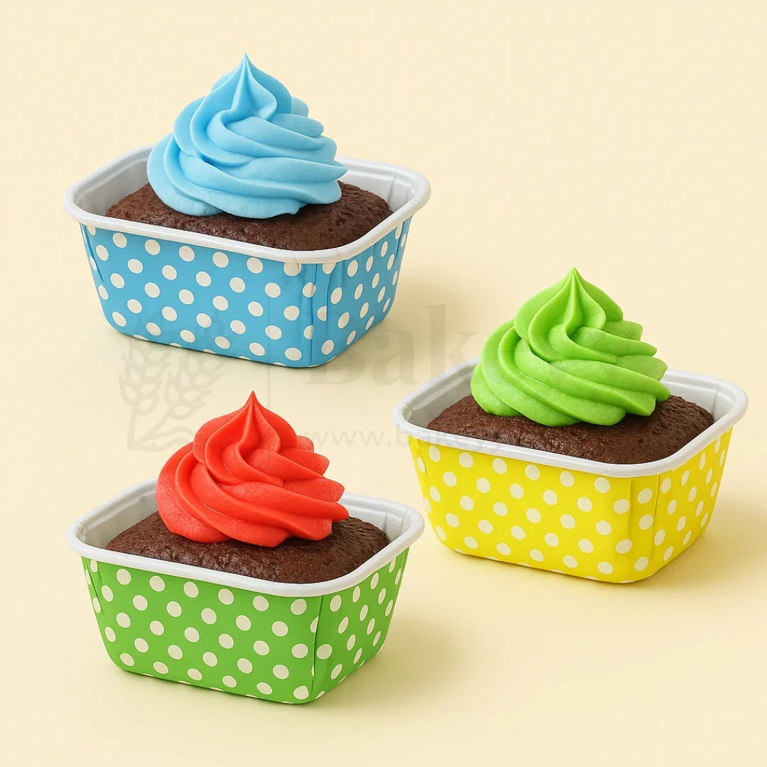 Three cupcakes with colorful frosting in polka dot containers on a beige background