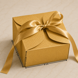 Gold gift box with a bow on a beige background