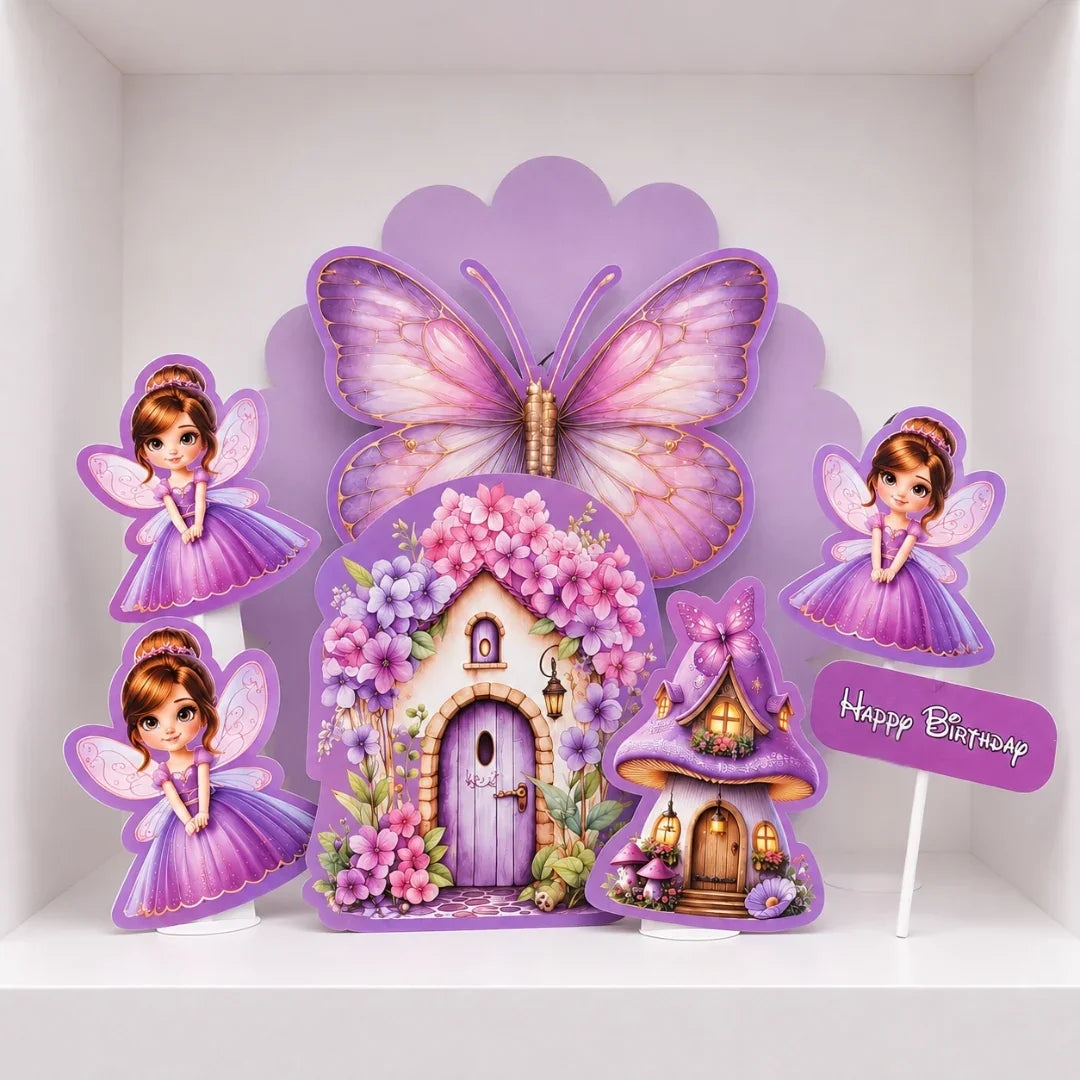 A purple fairy-themed birthday party decoration set featuring a large butterfly, two fairies, a flower-covered fairy house, a small mushroom house, and a 'Happy Birthday' sign, displayed on a white shelf.