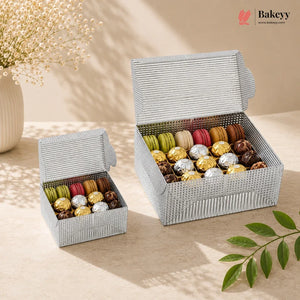 Two open wicker boxes filled with colorful macarons on a beige surface with a Bakeyy logo.
