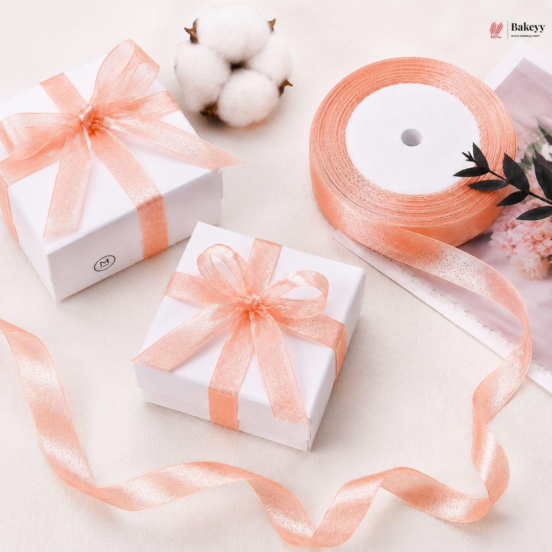 Two white gift boxes with peach ribbons on a light background