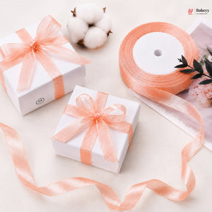 Two white gift boxes with peach ribbons on a light background