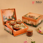 An orange decorative gift box set from Bakeyy, featuring an open box with three jars of sweets and a closed matching box on a beige background with decorative flower petals.