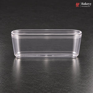 A clear plastic rectangular container with a flared rim, shown on a dark textured surface. The Bakeyy logo is visible in the top right corner.
