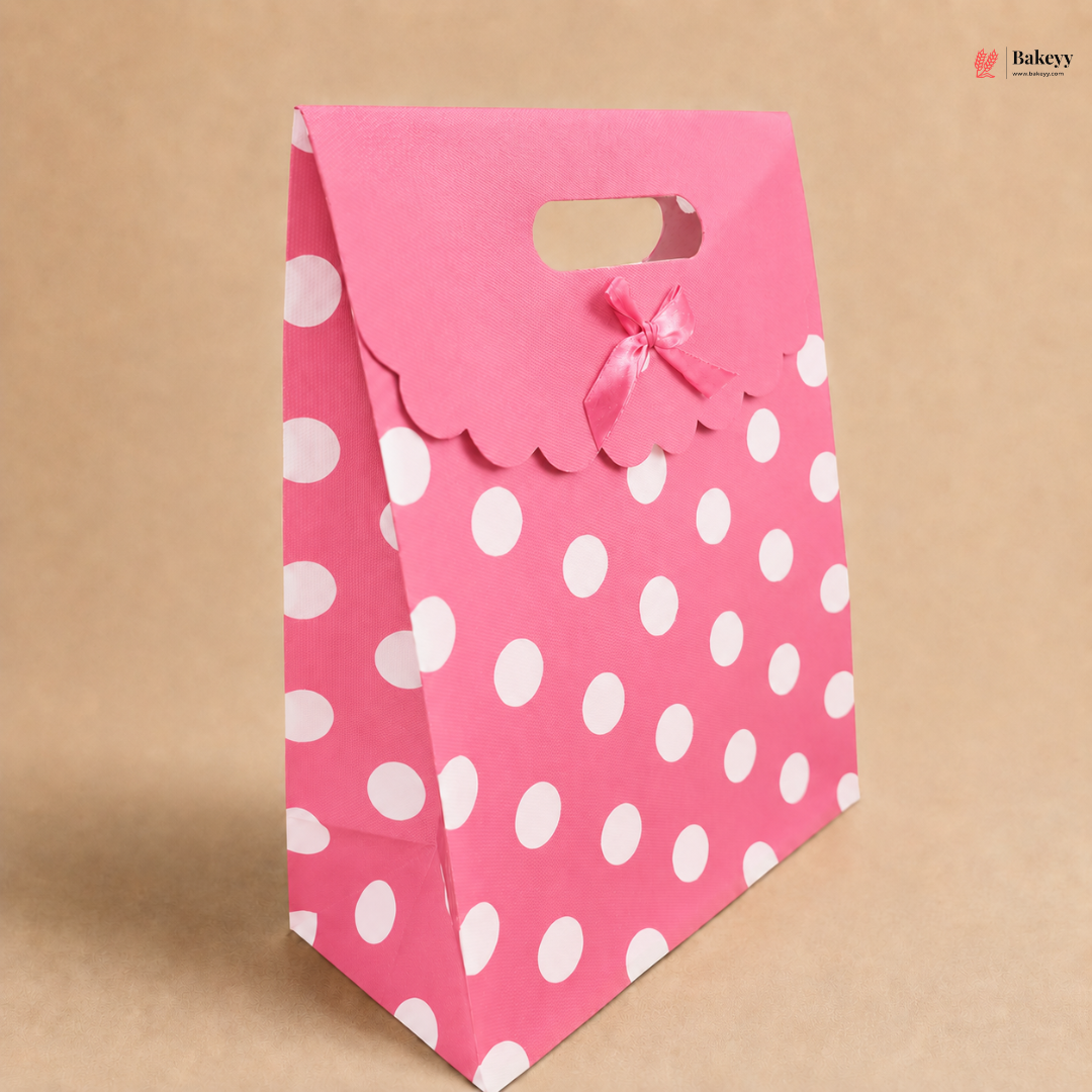 Pink paper bag with white polka dots and a bow on a beige background