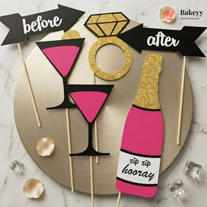 Decorative photo booth props including a martini glass, ring, and champagne bottle on sticks with 'before' and 'after' text, branded 'Bakeryy'.