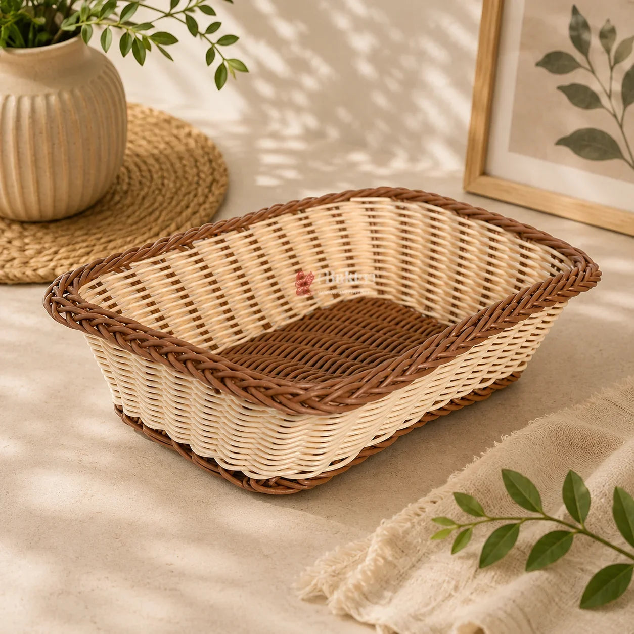 Woven bread basket on a light surface with a plant and framed picture in the background