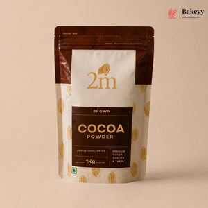 A 1kg stand-up pouch of 2m Brown Cocoa Powder, featuring a cream and dark brown design with gold cocoa bean illustrations, set against a solid beige background.