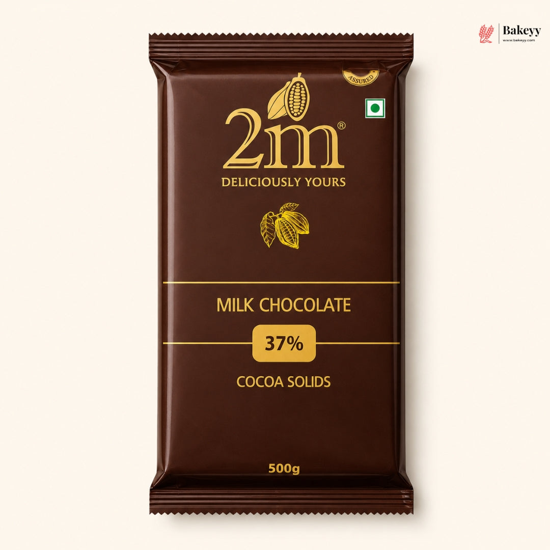 A 500g package of 2m Milk Chocolate 37% Cocoa Solids, shown against a light cream background. The packaging is dark brown with gold lettering and cocoa illustrations.