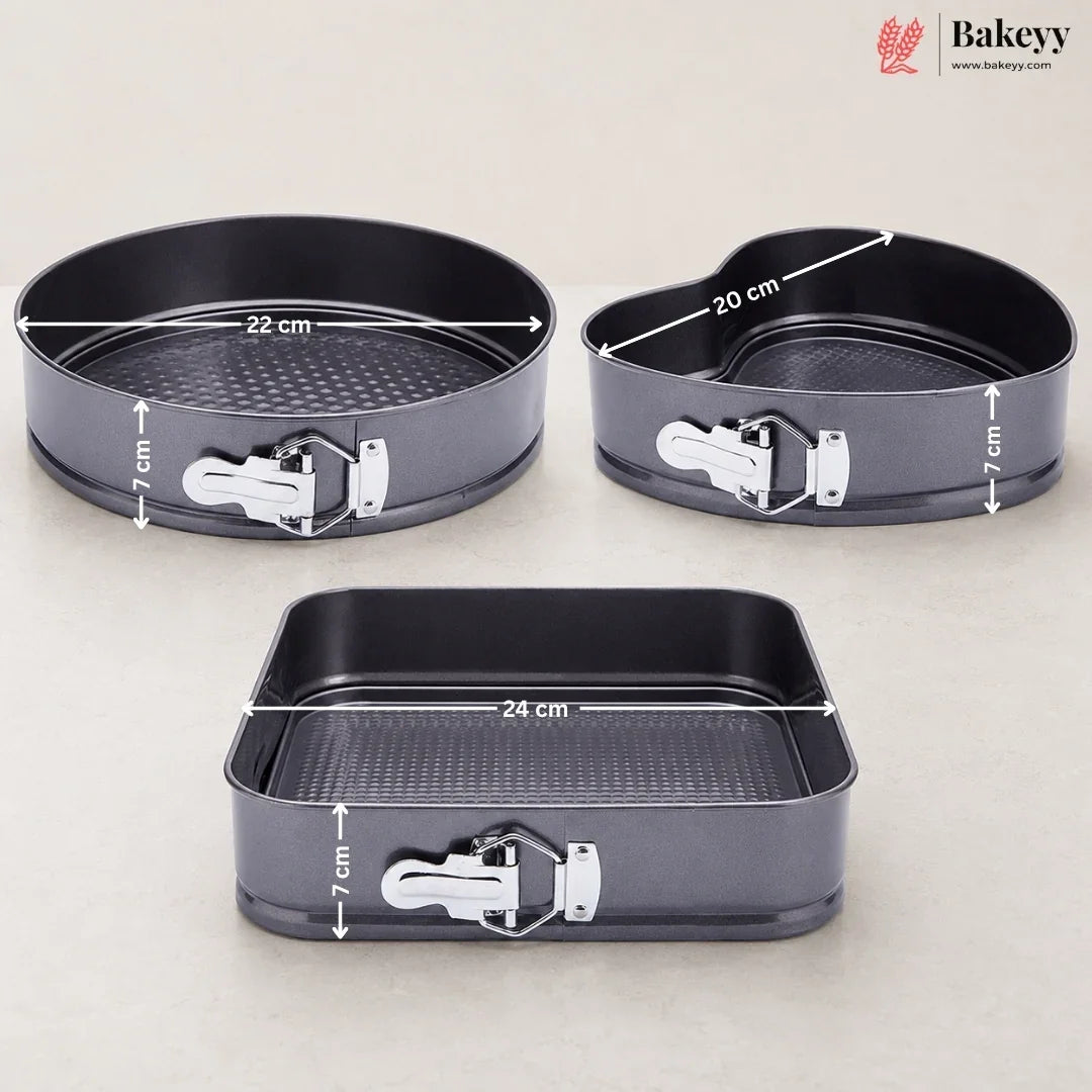 Three dark gray non-stick springform baking pans with white latch clasps, shown on a light beige background with overlaid dimension lines and text indicating 22 cm, 20 cm, and 24 cm diameters and 7 cm height. A Bakeey logo appears in the top right corner.