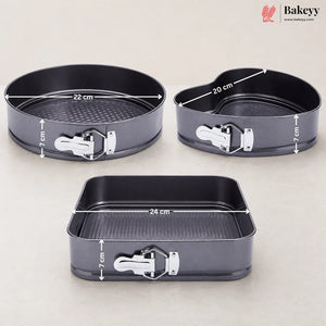 Three dark gray non-stick springform baking pans with white latch clasps, shown on a light beige background with overlaid dimension lines and text indicating 22 cm, 20 cm, and 24 cm diameters and 7 cm height. A Bakeey logo appears in the top right corner.