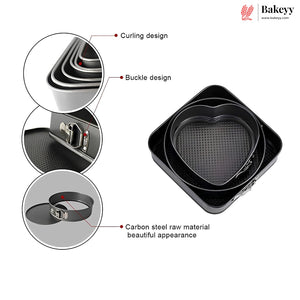 Black heart-shaped carbon steel springform cake pans shown with three circular detail callouts highlighting the curling design, buckle design, and raw material finish. The Bakeyy brand logo is visible in the top right corner.