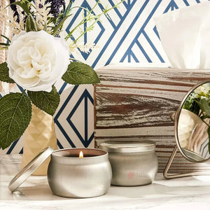 Silver tin scented candle and decor on marble surface, Bakeyy wholesale baking supplies.