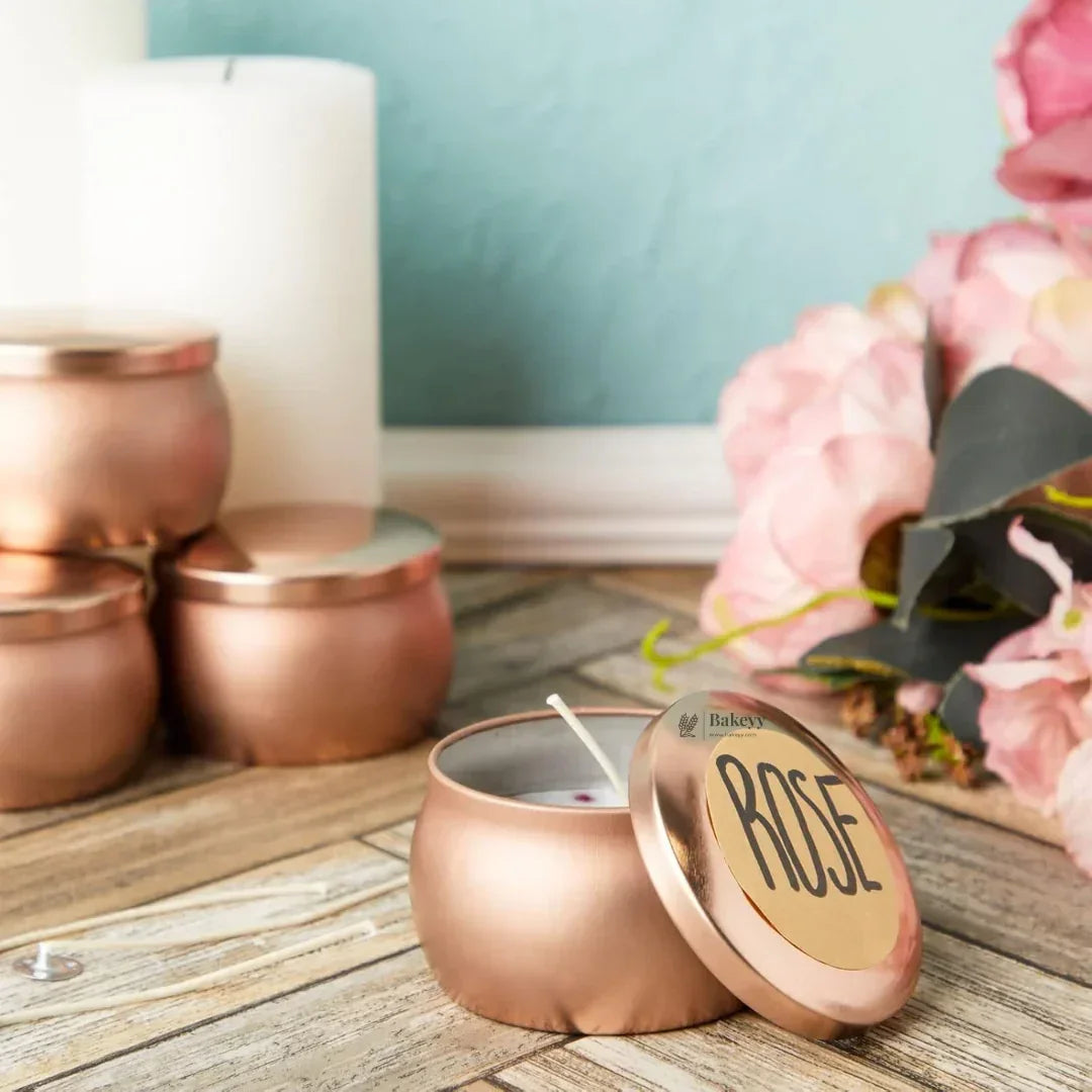 Rose gold candle tins labeled 'ROSE' with floral decor on a wooden surface from Bakeyy.com