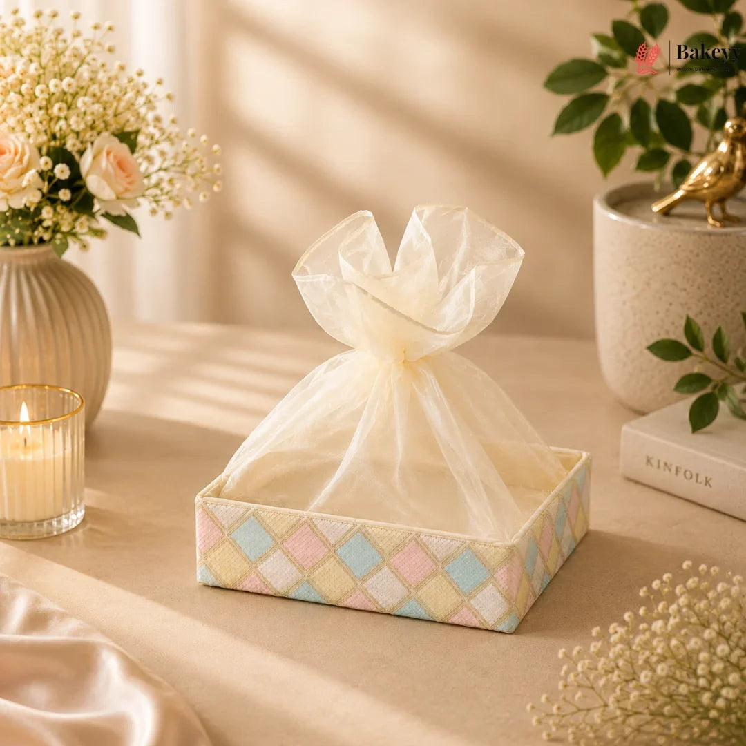 Decorative tissue box with a bow on a table with flowers and a candle