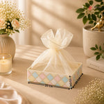 Decorative box with a sheer bow on a table with measurements indicated