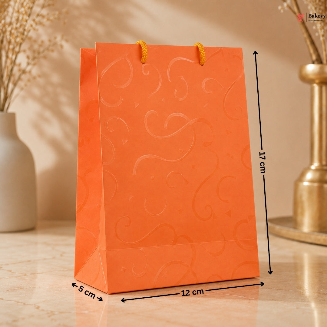 Orange paper bag with decorative patterns and measurements on a wooden surface.
