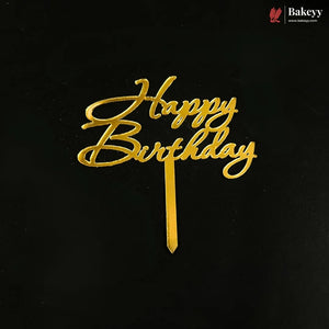 Gold metallic 'Happy Birthday' script cake topper on a black background, with a small Bakeyy logo in the top right corner.