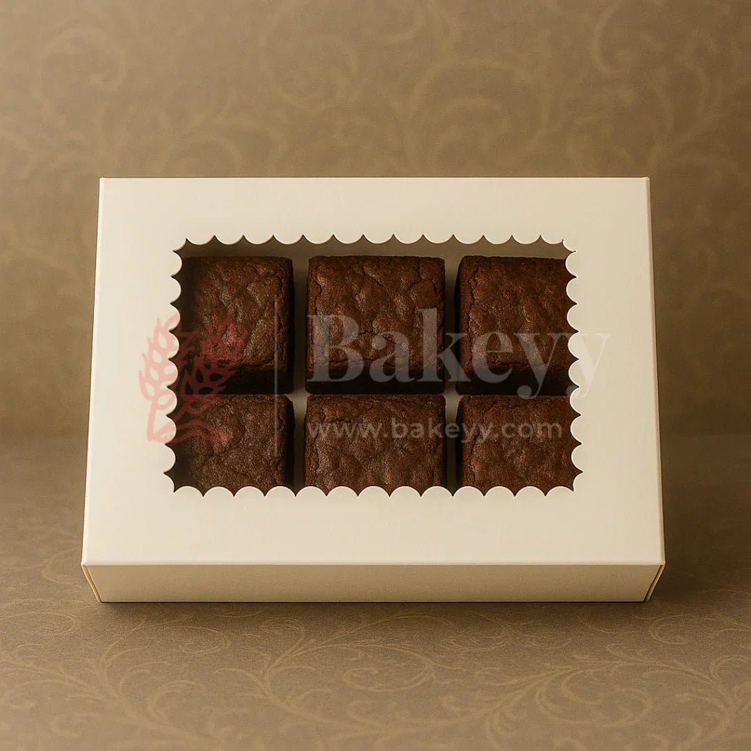 Six brownies in a white scalloped window bakery box on a beige background from Bakeyy.com