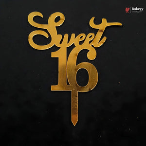 Gold metallic cake topper spelling 'Sweet 16' on a black background, with a small Bakeey logo in the top right corner.
