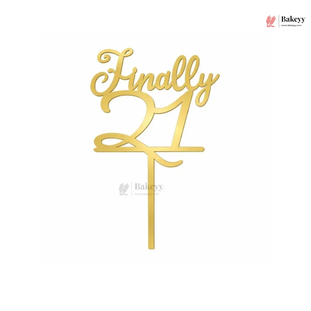 Gold acrylic table cake topper with the words 'Finally 21' on a white background.