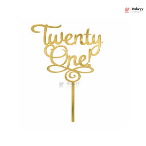 Gold metallic 'Twenty One!' script cake topper on a single stick, shown against a plain white background.