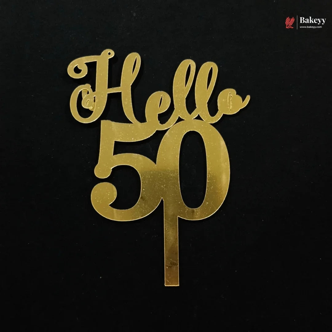 Gold metallic 'Hello 50' cake topper on a black background, with a small Bakeey logo in the top right corner.