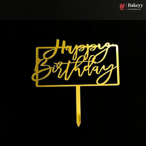 Gold metal 'Happy Birthday' cake topper with a rectangular border and stick base, shown on a black background. A Bakeey logo appears in the top right corner.