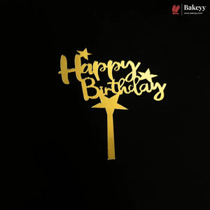 Gold 'Happy Birthday' cake topper with star accents and a stick, shown on a black background. A Bakeey logo is visible in the top right corner.