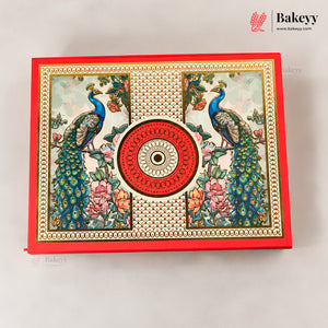 A decorative red rectangular box with ornate printed peacock and floral artwork, centered on a light neutral background. The box features a large circular red medallion motif in the middle and a repeating gold-toned border pattern.
