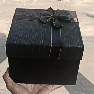 Black gift box with gold-trimmed ribbon bow for hamper or bakery packaging from Bakeyy.com