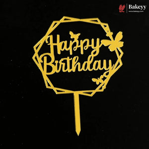A gold-colored metal 'Happy Birthday' cake topper with butterfly designs and a geometric frame, shown on a black background with a Bakeey brand logo in the top right corner.