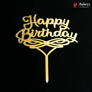 Gold metal 'Happy Birthday' cake topper with decorative swirls and a stick, shown on a black background. A Bakeey logo watermark is visible in the top right corner.