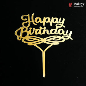 Gold metal 'Happy Birthday' cake topper with decorative swirls and a stick, shown on a black background. A Bakeey logo watermark is visible in the top right corner.