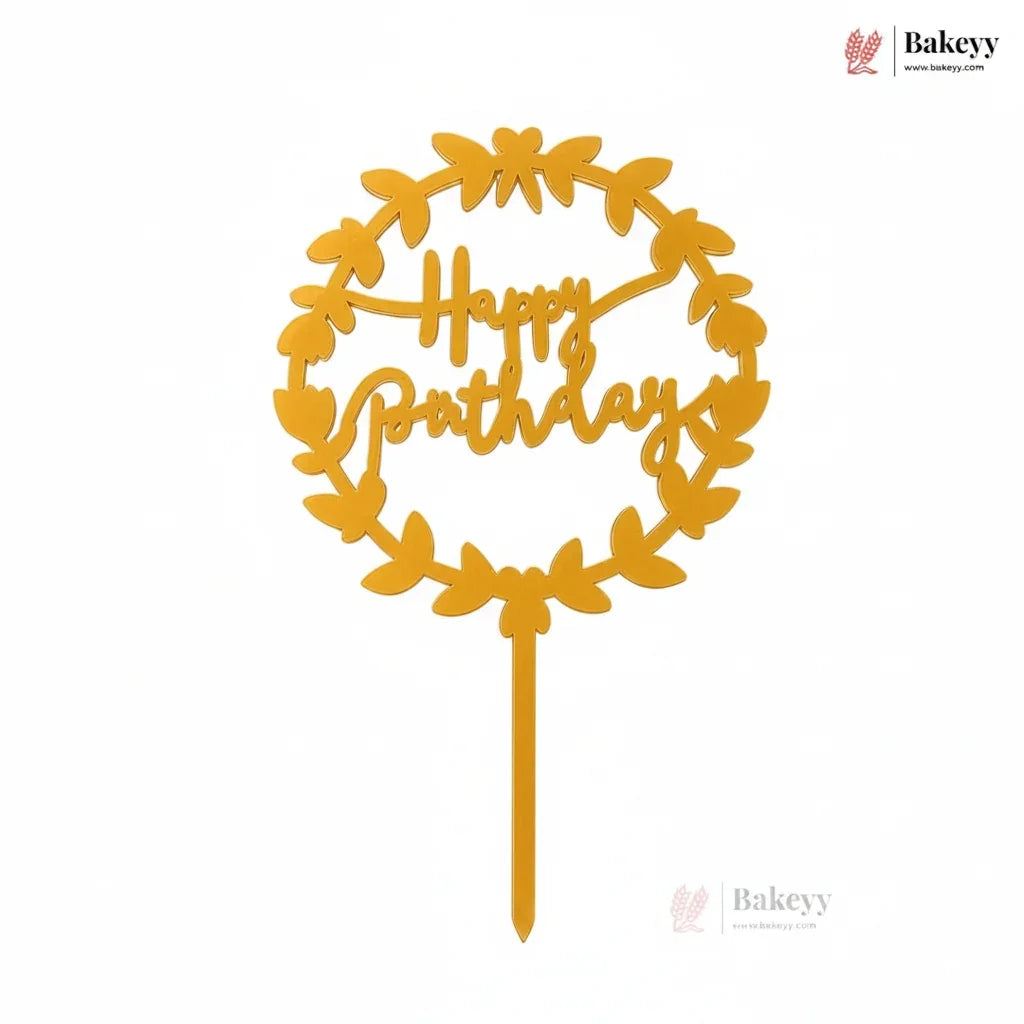 Yellow 'Happy Birthday' cake topper with leaf design on a white background, featuring Bakeyy branding.