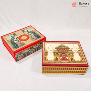 Two ornate decorative gift boxes with intricate hand-painted traditional Indian designs, one featuring peacocks and the other a palace motif, displayed on a white fabric background.