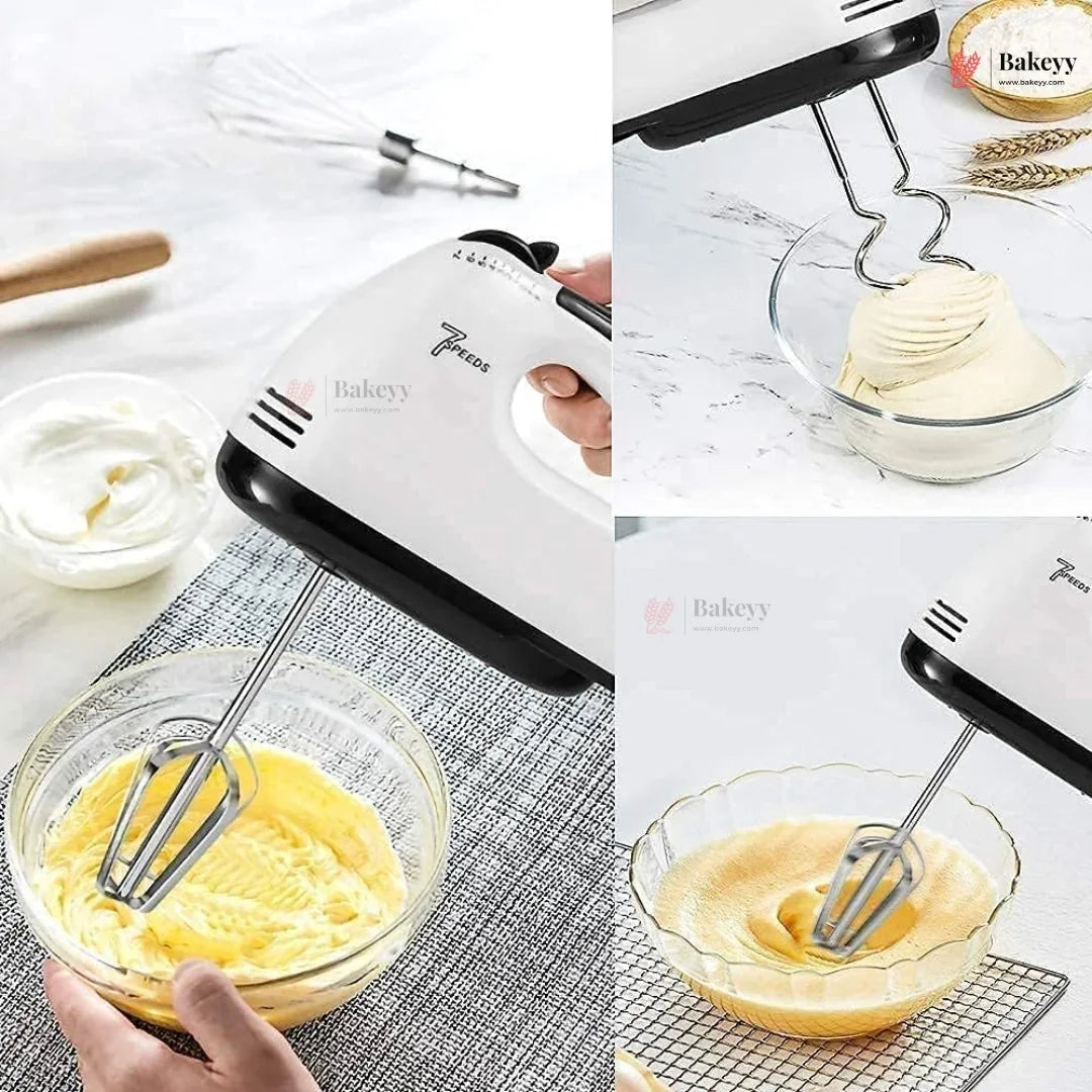 Hand mixer being used to whip cream and mix yellow batter in a glass bowl.