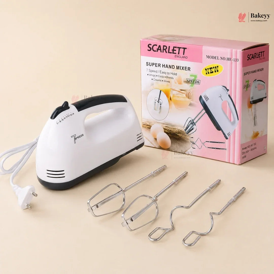 Scarlett hand mixer with attachments and packaging on a beige background