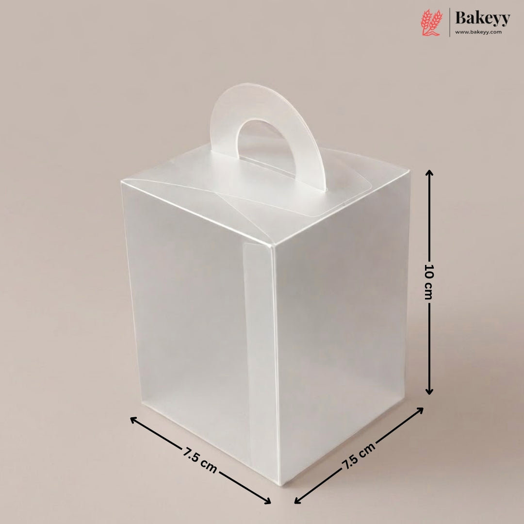 Clear plastic gift box with dimensions and handle on a beige background, featuring the brand 'Bakeyy'.