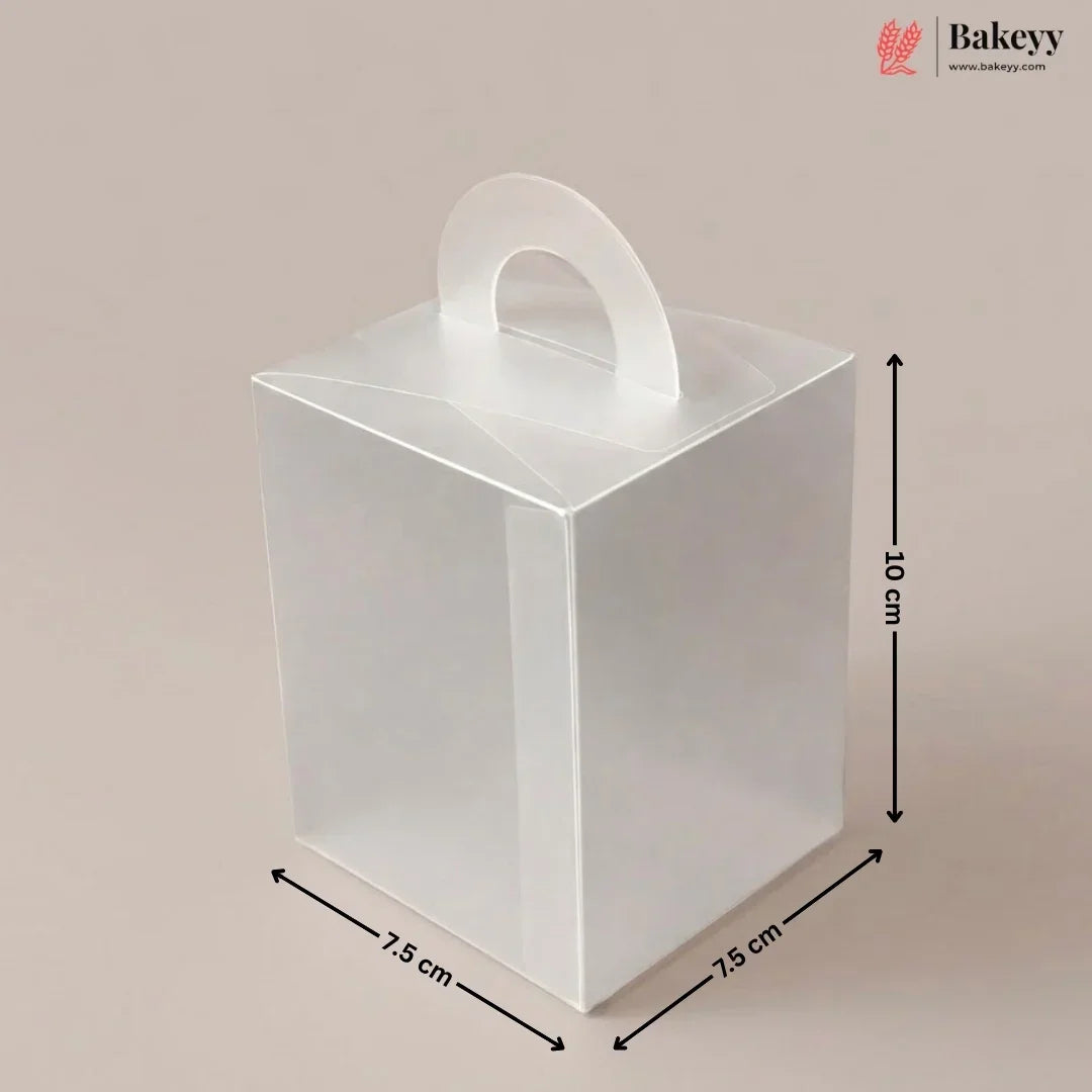 Clear plastic gift box with dimensions and handle on a beige background, featuring the brand 'Bakeyy'.