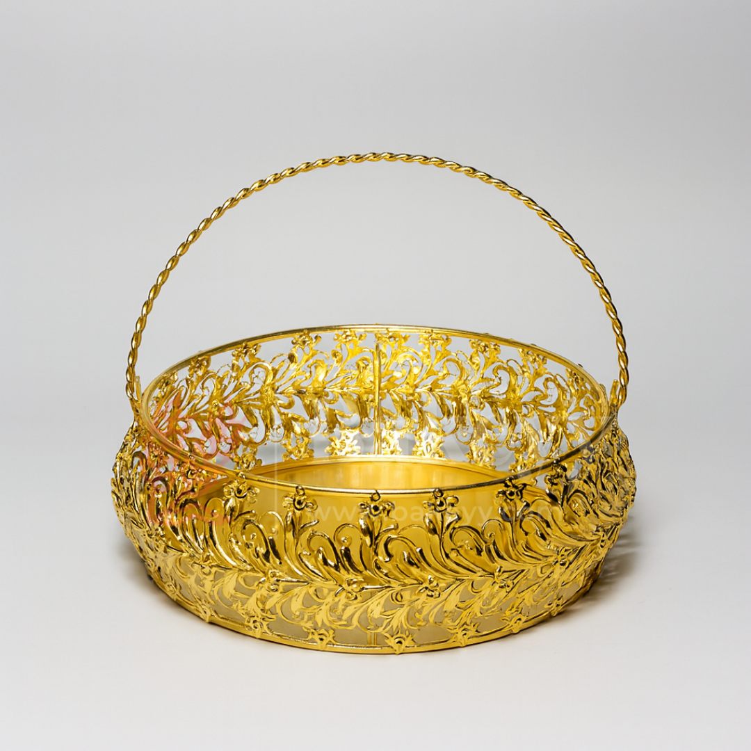 Gold decorative basket with intricate patterns on a light gray background