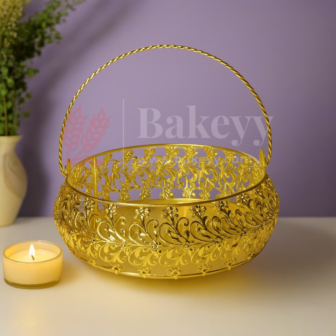 Decorative gold basket with intricate patterns on a light surface, next to a lit candle, with a purple background.