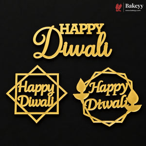 Three gold-colored Diwali-themed cake toppers or decorations on a black background, featuring the words 'Happy Diwali' in different geometric and circular frame designs. A Bakeyy logo is visible in the top right corner.