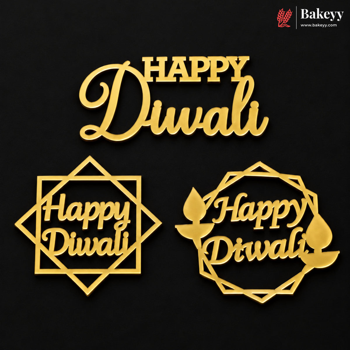Three gold-colored Diwali-themed cake toppers or decorations on a black background, featuring the words 'Happy Diwali' in different geometric and circular frame designs. A Bakeyy logo is visible in the top right corner.