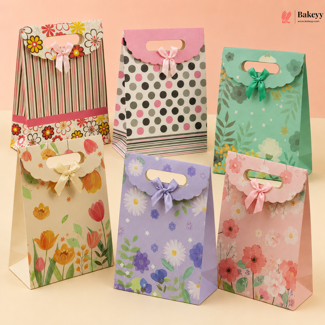 Set of colorful paper gift bags with floral designs on a light pink background.