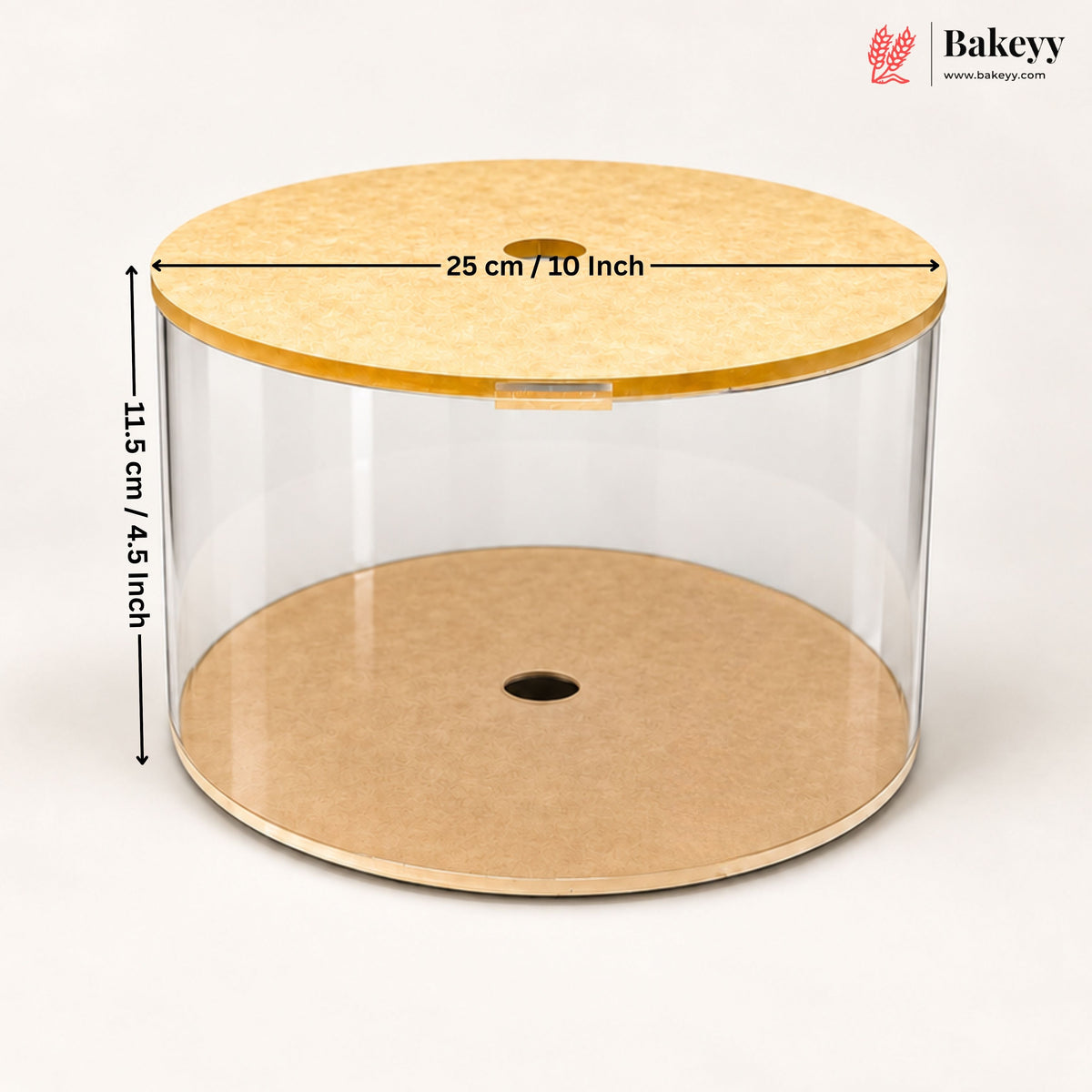Clear cylindrical cake display box with a light wood lid and base, shown on a white background with dimension arrows and text indicating 25 cm / 10 inch diameter and 11.5 cm / 4.