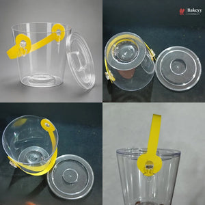 Clear plastic cup with yellow handle and lid on a gray background